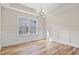 Light-filled dining room boasts classic wainscoting, stylish chandelier, and wood-look floors at 623 Carter Reid Ct., Longs, SC 29568