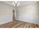 Bright dining room featuring classic wainscoting, and an elegant chandelier with wood-look floors at 623 Carter Reid Ct., Longs, SC 29568