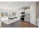 Modern kitchen features white cabinets, stainless steel appliances, and a quartz countertop island at 623 Carter Reid Ct., Longs, SC 29568