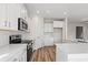 This is an open concept kitchen design with white cabinets, quartz countertops, and modern appliances at 623 Carter Reid Ct., Longs, SC 29568