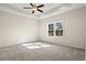Sunlit main bedroom boasts a tray ceiling, ceiling fan, plush carpet and large window at 623 Carter Reid Ct., Longs, SC 29568
