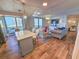 Bright, open-concept living area with wood floors, ocean views, stylish furnishings, and balcony access at 8560 Queensway Blvd. # 104, Myrtle Beach, SC 29572