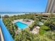 Aerial view of the pool area, ocean, and lush landscaping at 8560 Queensway Blvd. # 104, Myrtle Beach, SC 29572