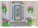Close-up of the front door with decorative glass, framed by flower-filled planters at 5303 Pheasant Dr., North Myrtle Beach, SC 29582