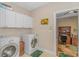 Functional laundry room with washer, dryer, white cabinets, and access to an office space at 5303 Pheasant Dr., North Myrtle Beach, SC 29582