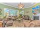 Spacious living room featuring large windows, comfortable seating, fireplace, and decorative ceiling fan at 5303 Pheasant Dr., North Myrtle Beach, SC 29582