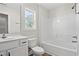 Bathroom with white tub and shower, vanity, and a window at 639 Carter Reid Ct., Longs, SC 29568