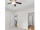 Bright primary bedroom with tray ceiling, ceiling fan, carpeted floor, and ensuite bath entrance at 639 Carter Reid Ct., Longs, SC 29568
