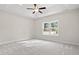 Spacious bedroom with plush carpet, a ceiling fan, and a large window at 639 Carter Reid Ct., Longs, SC 29568