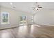 Bright living room with wood floors, vaulted ceiling, and sliding glass doors to the backyard at 639 Carter Reid Ct., Longs, SC 29568