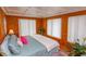 Comfortable bedroom with wood walls, large windows, and a cozy bed at 526 Dogwood Dr. N, Garden City Beach, SC 29576