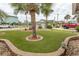 Well-manicured front yard with lush, artificial turf, mature palm trees, and decorative landscaping at 526 Dogwood Dr. N, Garden City Beach, SC 29576