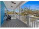 Covered porch with ceiling fans, light gray floors, white railing, and black rocking chairs at 514 Vista Dr., Murrells Inlet, SC 29576