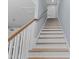 View of a wooden staircase with white risers, railings, and light blue wall at 514 Vista Dr., Murrells Inlet, SC 29576