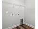 The laundry room has white walls, wood-look flooring, and essential hookups for convenient laundry tasks at 132 Oak Bay Dr., Georgetown, SC 29440