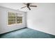 Simple bedroom with teal carpet, ceiling fan, and large window at 2201 John Henry Ln., Myrtle Beach, SC 29579