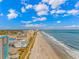 Breathtaking aerial view showcasing the coastline, buildings, and beach, all under a bright blue, cloudy sky at 1605 S Ocean Blvd. # 410, Myrtle Beach, SC 29577