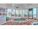 Inviting indoor hot tub surrounded by windows with views of tropical landscaping and condo buildings at 1605 S Ocean Blvd. # 410, Myrtle Beach, SC 29577