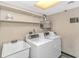 Basic community laundry room with two washing machines, a sink, and storage shelving at 1605 S Ocean Blvd. # 410, Myrtle Beach, SC 29577