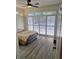 Bright bedroom with plank floors, ceiling fan, and access to the balcony with window shutters at 144 Waterway Crossing Ct., Little River, SC 29566