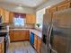 Well-lit kitchen with wood cabinets, stainless steel refrigerator and view of a window and sink at 144 Waterway Crossing Ct., Little River, SC 29566