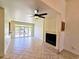 Open living room showcasing tile floors, a fireplace, ceiling fan and large glass doors to the outside at 144 Waterway Crossing Ct., Little River, SC 29566