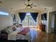 Vaulted main bedroom featuring a ceiling fan, wood floors, balcony, and a comfortable seating area at 144 Waterway Crossing Ct., Little River, SC 29566