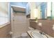Bathroom with light blue upper walls, shower and tub, toilet, sink, mirror, and small window at 705 White Oak Dr., Johnsonville, SC 29555