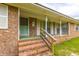 A welcoming front porch with brick steps and green mat, leading to the front door of this charming home at 705 White Oak Dr., Johnsonville, SC 29555