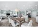 Bright dining area with wooden table, light colored chairs, and ocean view at 5207 Ocean Blvd. N, North Myrtle Beach, SC 29582