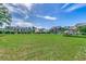 Expansive green lawn with mature trees, picnic shelter, and building exteriors under a bright blue sky at 1095 W Plantation Dr. W # 28D, Little River, SC 29566