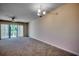 Spacious living room featuring a ceiling fan, a sliding glass door, and neutral carpeting at 1095 W Plantation Dr. W # 28D, Little River, SC 29566