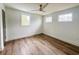 Bright bedroom with hardwood floors, three large windows, and a modern ceiling fan for comfortable living at 189 Brown Pelican Loop, Pawleys Island, SC 29585