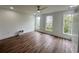Bright bedroom with hardwood floors, a modern ceiling fan, and ample natural light streaming through multiple windows at 189 Brown Pelican Loop, Pawleys Island, SC 29585