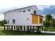 Two-story home with white and yellow siding, elevated foundation, and golf cart at 189 Brown Pelican Loop, Pawleys Island, SC 29585