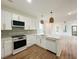 Open concept kitchen featuring white cabinets, quartz countertops, gold hardware, and pendant lighting at 189 Brown Pelican Loop, Pawleys Island, SC 29585