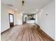 Open concept living room with wood floors and view of kitchen with white cabinets and gold hardware at 189 Brown Pelican Loop, Pawleys Island, SC 29585