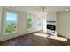 Sunlit living room with hardwood floors, a modern fireplace, and picturesque views from the multiple windows at 189 Brown Pelican Loop, Pawleys Island, SC 29585
