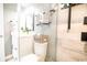 Contemporary bathroom with a glass-enclosed shower, white vanity, and practical storage basket on the toilet at 5800 N Ocean Blvd. # 705, North Myrtle Beach, SC 29582