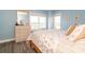 Inviting bedroom featuring blue walls, a large window, and a decorative dresser and mirror at 5800 N Ocean Blvd. # 705, North Myrtle Beach, SC 29582