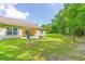 Large backyard featuring a covered patio, a fire pit, and mature trees surrounding the property at 252 Timber Run Dr., Georgetown, SC 29440