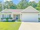 Tan house with white garage door, landscaping, and driveway at 252 Timber Run Dr., Georgetown, SC 29440