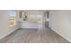 An open-concept room featuring new gray vinyl plank flooring, bright walls, and modern gray kitchen cabinetry at 116 Arbor Crest Ln., Tabor City, NC 28463