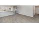 A cozy room featuring new gray vinyl plank flooring with kitchen and bathroom view at 116 Arbor Crest Ln., Tabor City, NC 28463