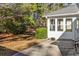 Concrete patio adjacent to the sunroom, surrounded by trees at 6625 Scotsman Crescent, Myrtle Beach, SC 29588