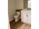 Modern powder room features white vanity, toilet and wood-look flooring at 882 Liberty Church Rd., Loris, SC 29569