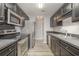 Galley kitchen with stainless steel appliances and black cabinets at 9138 Wildwood Pl., Murrells Inlet, SC 29576