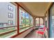 Relaxing screened porch with red chairs and outdoor table at 501 Maison Dr. # B3, Myrtle Beach, SC 29572