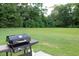 A backyard with a grill and a large grass lawn at 157 Blue Jacket Dr., Galivants Ferry, SC 29544