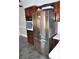 Stainless steel refrigerator in a kitchen with dark wood cabinets at 5632 Main St., Loris, SC 29569